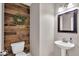 Charming powder room with wood accent wall, pedestal sink, decorative wreath, and a decorative framed mirror at 2434 Burgundy Way, Plainfield, IN 46168