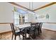 Bright dining room features a large window, wood-look floors, trim detail, and modern light fixture at 2818 Locust Dr, Indianapolis, IN 46227