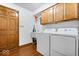 Functional laundry room features wooden cabinets, utility sink, and modern washer and dryer at 2818 Locust Dr, Indianapolis, IN 46227