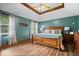 Spacious main bedroom with tray ceiling, wood-look flooring, and bright natural light at 2818 Locust Dr, Indianapolis, IN 46227