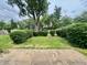 Landscaped backyard featuring a well manicured lawn, trimmed hedges, and mature trees at 2833 Desoto Way, Columbus, IN 47203