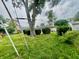 View of backyard featuring a lawn, chain link fence, mature trees, and bushes at 2833 Desoto Way, Columbus, IN 47203