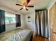 Comfortable bedroom with neutral walls, ceiling fan, dark curtains, a flower pot and a cozy single bed at 2833 Desoto Way, Columbus, IN 47203