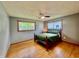Inviting bedroom with hardwood floors, soft green bedding, natural lighting, ceiling fan, and two windows at 2833 Desoto Way, Columbus, IN 47203