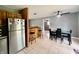 Open-concept dining area with bar, tiled floor, ceiling fan, stainless steel refrigerator, and a dining table at 2833 Desoto Way, Columbus, IN 47203