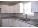 Close-up of updated kitchen with granite countertops, stainless sink, and pristine white cabinets at 3026 Stuart St, Indianapolis, IN 46218