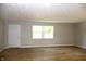 Inviting living room with light wood flooring, neutral paint, recessed lights, and a bright window at 3026 Stuart St, Indianapolis, IN 46218