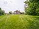 Spacious backyard with a view of the home, featuring a well-kept lawn and recreation areas at 312 Hawthorne Dr, Pittsboro, IN 46167