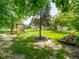 Shaded backyard features a play set, mature trees, and access to the main house at 312 Hawthorne Dr, Pittsboro, IN 46167