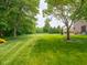 Large grassy backyard with mature trees creating a private, park-like setting at 312 Hawthorne Dr, Pittsboro, IN 46167