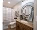 Cozy bathroom featuring a modern round mirror and traditional-style vanity cabinet at 312 Hawthorne Dr, Pittsboro, IN 46167