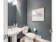 Powder room featuring a pedestal sink, modern fixture, and gray walls at 312 Hawthorne Dr, Pittsboro, IN 46167