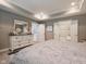 Bright bedroom with a white dresser, soft gray walls, and an ensuite bathroom at 312 Hawthorne Dr, Pittsboro, IN 46167