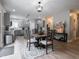 Open dining area with gray walls, gray kitchen cabinets, and hardwood floors at 312 Hawthorne Dr, Pittsboro, IN 46167