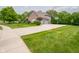 Home featuring a large driveway, basketball hoop, and well-maintained lawn at 312 Hawthorne Dr, Pittsboro, IN 46167