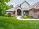 Inviting brick home with a lush front lawn and covered front porch at 312 Hawthorne Dr, Pittsboro, IN 46167