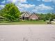Attractive brick home with a well-kept lawn, trimmed bushes, and mature trees at 312 Hawthorne Dr, Pittsboro, IN 46167
