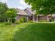 Beautiful brick home with lush landscaping, mature trees, and a well-maintained lawn at 312 Hawthorne Dr, Pittsboro, IN 46167