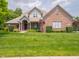 Charming brick home featuring a well-manicured lawn and inviting covered porch at 312 Hawthorne Dr, Pittsboro, IN 46167