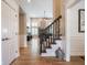 Open foyer with hardwood floors leading to a living room with a fireplace and a staircase to the upper level at 312 Hawthorne Dr, Pittsboro, IN 46167