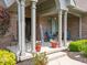 Charming covered porch with chairs, potted plants, and decorative welcome sign at 312 Hawthorne Dr, Pittsboro, IN 46167
