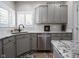 Modern kitchen featuring granite countertops, gray cabinets and stainless steel dishwasher at 312 Hawthorne Dr, Pittsboro, IN 46167