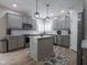 Well-lit modern kitchen with gray cabinets, an island, and stainless steel appliances at 312 Hawthorne Dr, Pittsboro, IN 46167