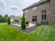 Back patio of brick house with outdoor seating and well-manicured landscaping at 312 Hawthorne Dr, Pittsboro, IN 46167