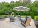 Outdoor patio space with comfortable seating, an umbrella, and mature landscaping at 312 Hawthorne Dr, Pittsboro, IN 46167