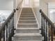 Carpeted staircase featuring a dark wood railing provides access to the upper levels of the home at 312 Hawthorne Dr, Pittsboro, IN 46167