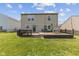 View of the backyard with a wooden deck, green grass and a two-story home at 3349 Capsella Ln, Indianapolis, IN 46203