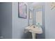 Powder room with pedestal sink, mirror and blue walls at 3349 Capsella Ln, Indianapolis, IN 46203