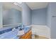 Light and airy bathroom with blue walls, a large mirror and a built-in bathtub at 3349 Capsella Ln, Indianapolis, IN 46203