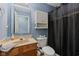 Functional bathroom with single sink vanity, toilet, and a shower with a dark shower curtain at 3349 Capsella Ln, Indianapolis, IN 46203