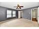 Carpeted bedroom featuring a ceiling fan, two windows, and a closet at 3429 Pavetto Ln, Indianapolis, IN 46203