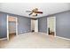Spacious bedroom with multiple doorways, a ceiling fan, and neutral carpeting at 3429 Pavetto Ln, Indianapolis, IN 46203