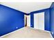 This is a bedroom featuring a window, blue walls, neutral carpet, and a closet at 3429 Pavetto Ln, Indianapolis, IN 46203