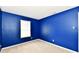 Stylish bedroom design exhibiting blue walls, neutral carpet, and a large window for natural light at 3429 Pavetto Ln, Indianapolis, IN 46203