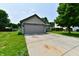 Charming home featuring a two-car garage, green lawn, and driveway at 3429 Pavetto Ln, Indianapolis, IN 46203