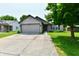 Charming single-story home featuring a two-car garage, green lawn, and mature trees at 3429 Pavetto Ln, Indianapolis, IN 46203