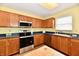 Well-lit kitchen offers stainless steel appliances, wood cabinets, and tile flooring at 3429 Pavetto Ln, Indianapolis, IN 46203