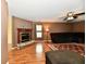 Open-concept living room with a fireplace, comfy sofa, ceiling fan and wood-look floors at 3429 Pavetto Ln, Indianapolis, IN 46203
