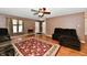 Spacious living room with a ceiling fan, plush furniture, and a patterned rug over wood-look flooring at 3429 Pavetto Ln, Indianapolis, IN 46203
