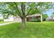 Exterior view of a single-story home with a well-manicured lawn and mature tree in the front yard at 4007 Knollwood Ave, Franklin, IN 46131