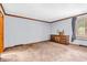 This bedroom features carpeted floors, a natural wood dresser, and baseboard trim at 407 Woodland E Dr, Greenfield, IN 46140