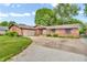 Single story brick home featuring an attached garage, concrete driveway, and lush green landscaping at 407 Woodland E Dr, Greenfield, IN 46140