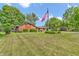 A well-manicured lawn highlights this beautiful brick home with an American flag at 407 Woodland E Dr, Greenfield, IN 46140