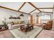 Comfortable living room showcasing vaulted ceilings, wooden beams, and a cozy seating arrangement at 407 Woodland E Dr, Greenfield, IN 46140