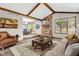 Inviting living room featuring a brick fireplace, wood beams, and an elegant area rug at 407 Woodland E Dr, Greenfield, IN 46140