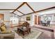 Open-concept living room with vaulted ceilings, wood beams, and elevated dining area at 407 Woodland E Dr, Greenfield, IN 46140
